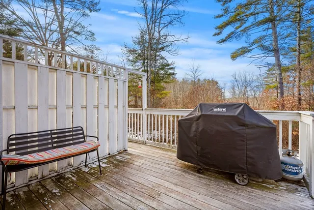 a balcony with wooden floor table and chairs