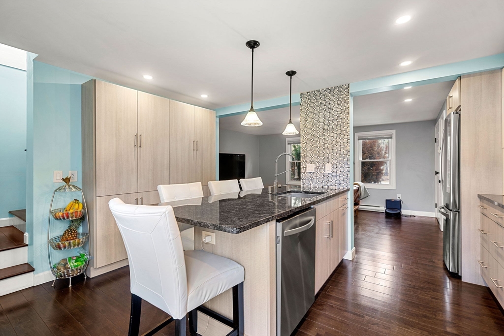 3-5 Roxanne Road Groton, MA 01450 - Photo 4 of 28 a kitchen with stainless steel appliances granite countertop a stove a sink a dining table and chairs with wooden floor