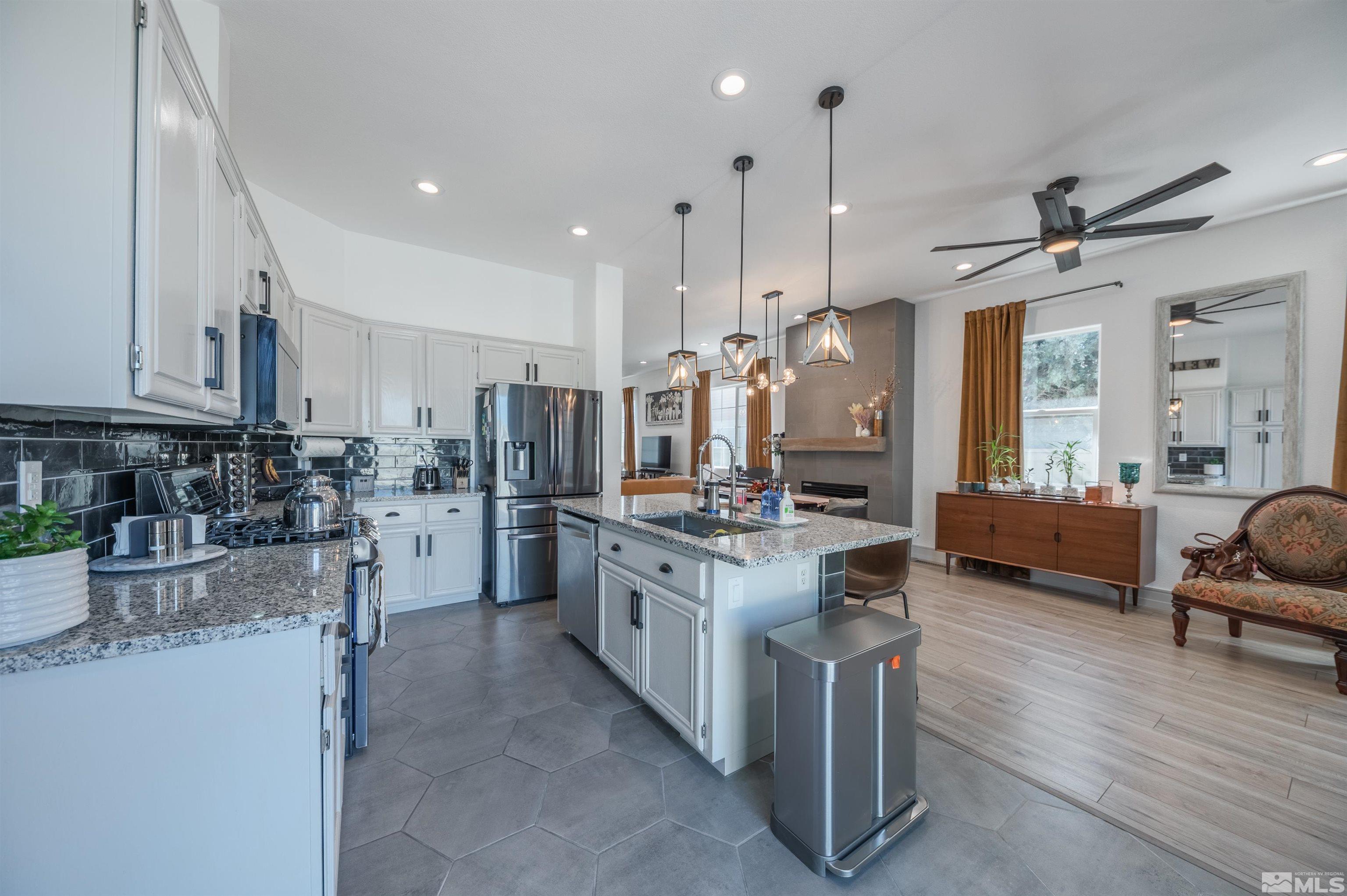 9857 Northrup Drive Reno, NV 89521 - Photo 12 of 27 a kitchen with stainless steel appliances kitchen island granite countertop a stove and a sink
