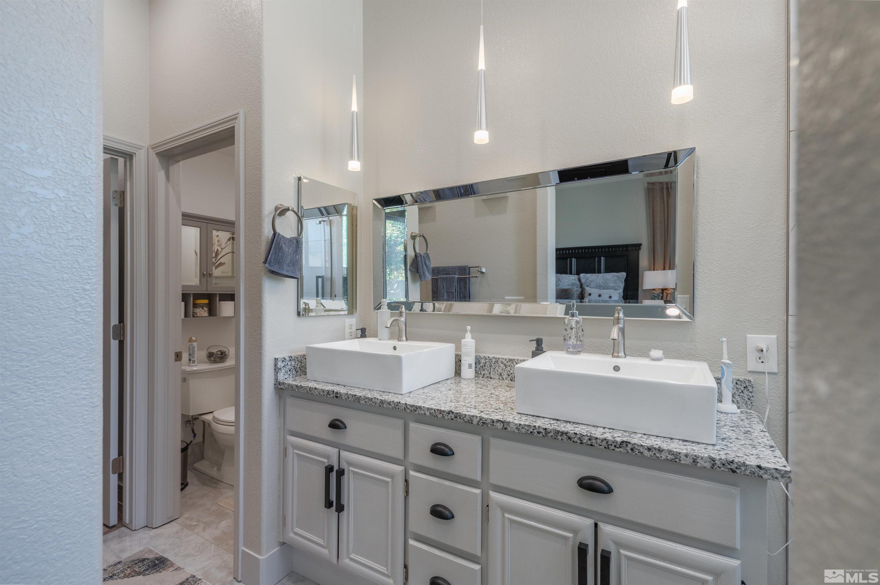 9857 Northrup Drive Reno, NV 89521 - Photo 19 of 27 a bathroom with double sink and a mirror