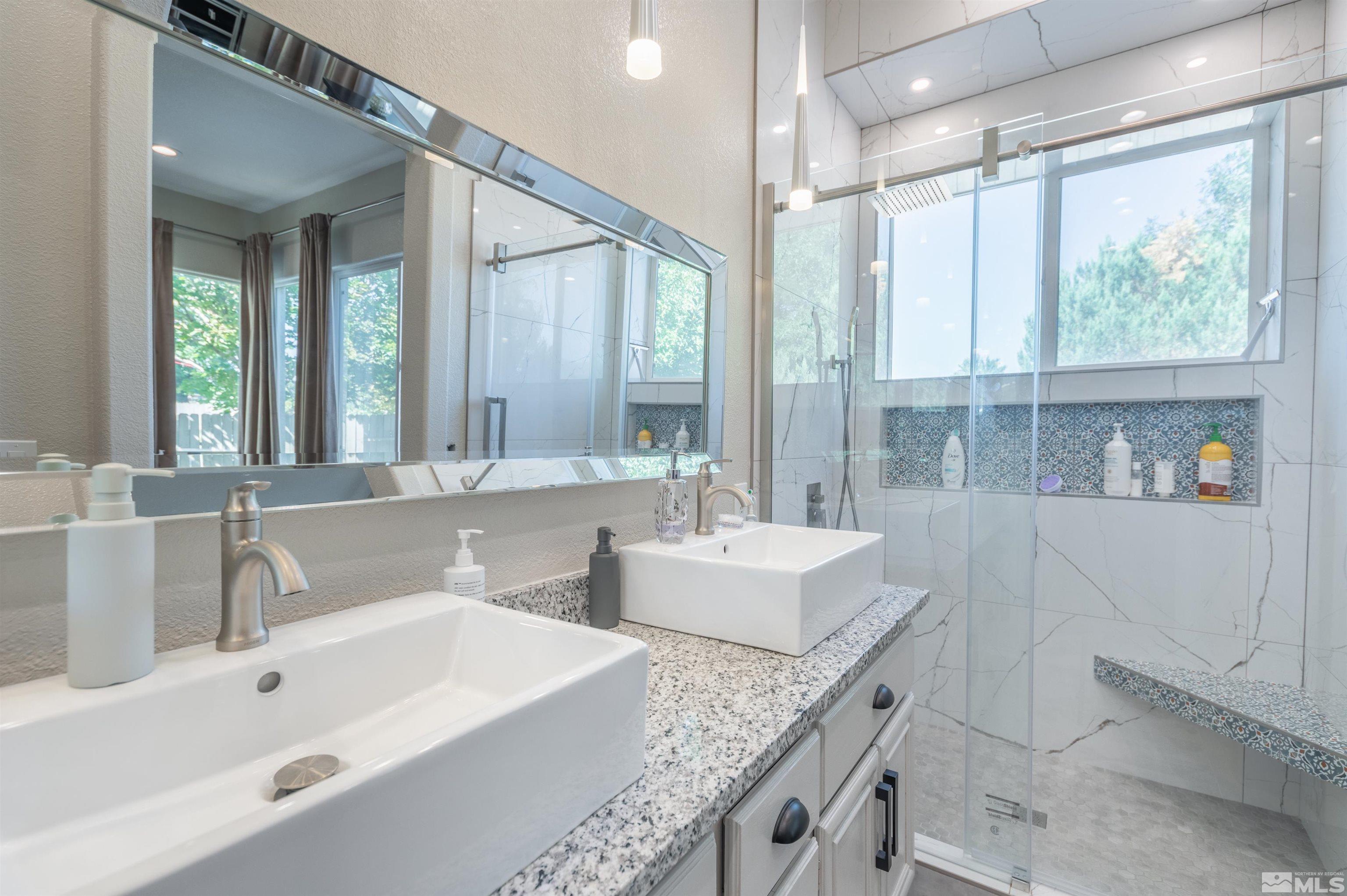 9857 Northrup Drive Reno, NV 89521 - Photo 20 of 27 a bathroom with double vanity sinks a large mirror and a bathtub