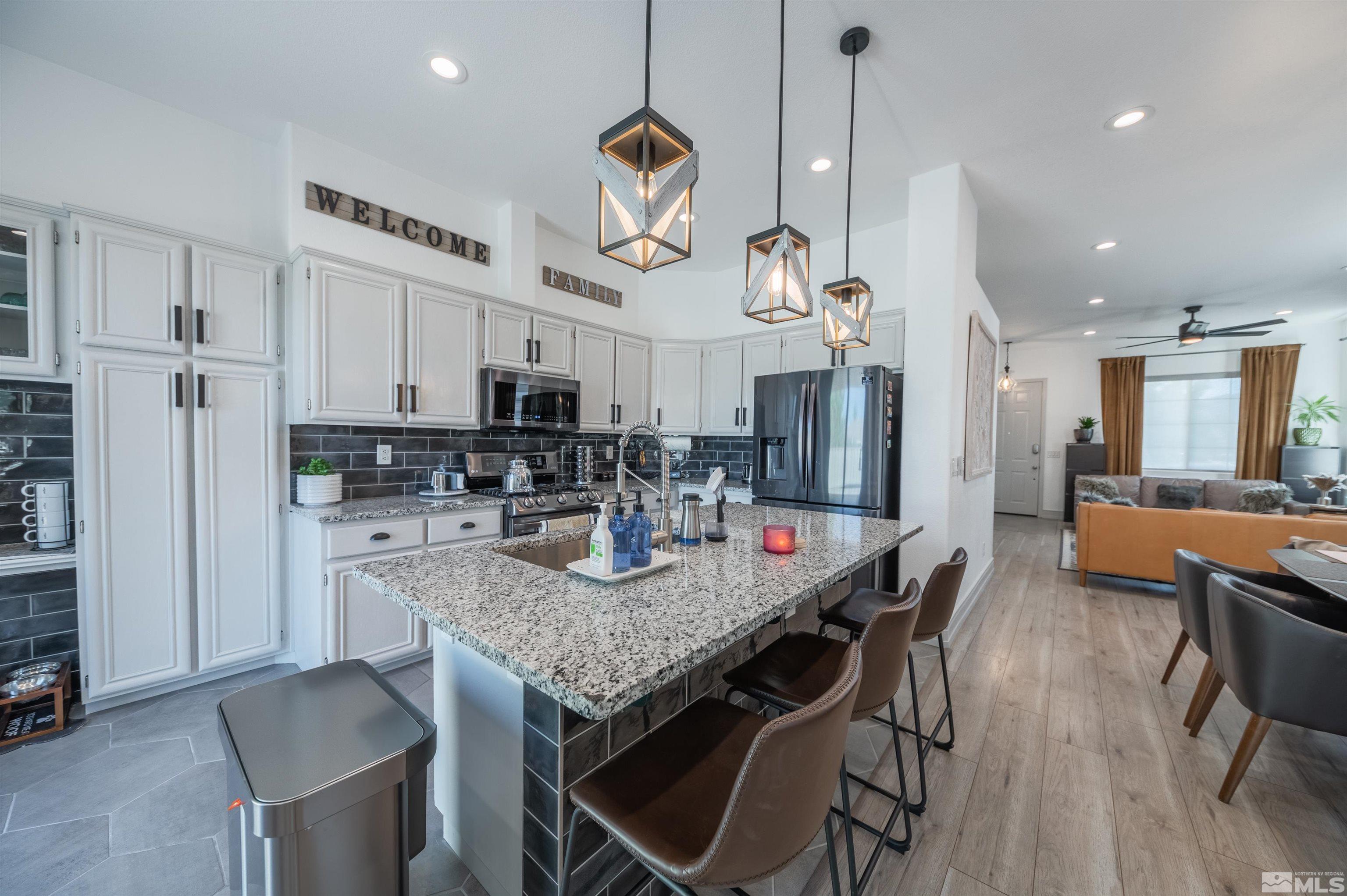 9857 Northrup Drive Reno, NV 89521 - Photo 10 of 27 a kitchen with stainless steel appliances granite countertop a kitchen island a stove a table and chairs