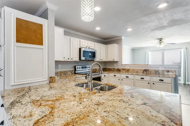 a kitchen with kitchen island granite countertop a stove sink cabinets and refrigerator