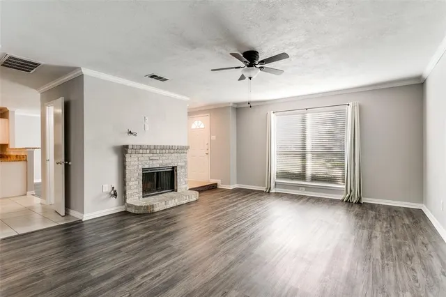 a view of a livingroom with a fireplace wooden floor and windows