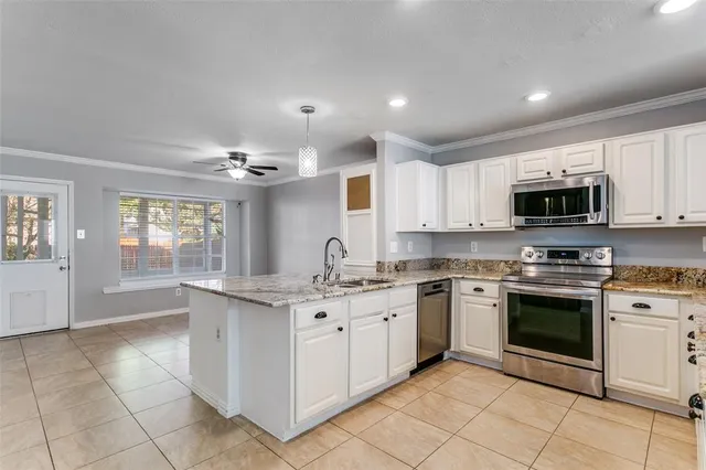 a kitchen with stainless steel appliances granite countertop a stove top oven a sink dishwasher and a refrigerator