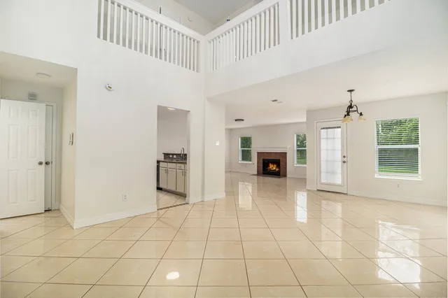 a view of a livingroom with a fireplace a window and stairs