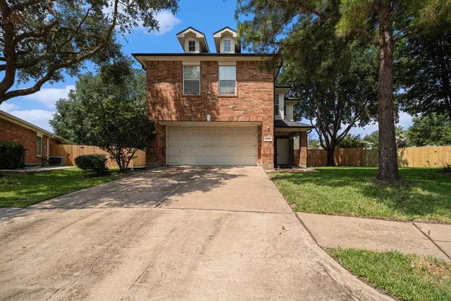 a front view of house with yard and trees around