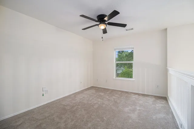 an empty room with a window and a fan