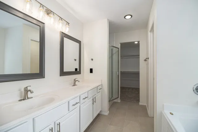 a bathroom with double sink and a mirror