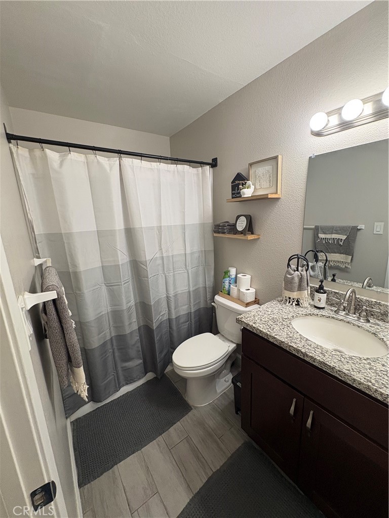 2255 Cahuilla Street, Unit 49 Colton, CA 92324 - Photo 16 of 19 a bathroom with a granite countertop sink toilet and shower
