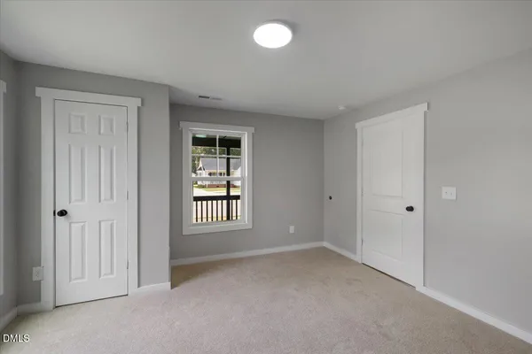 an empty room with windows and closet