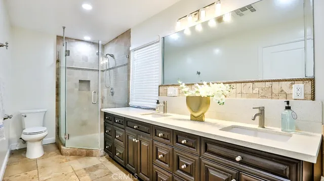 a bathroom with a double vanity sink mirror and toilet