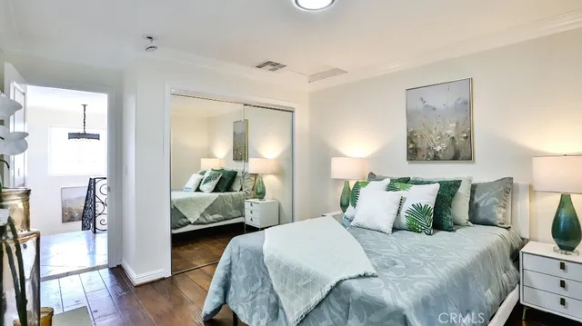 a bedroom with a bed and wooden floor