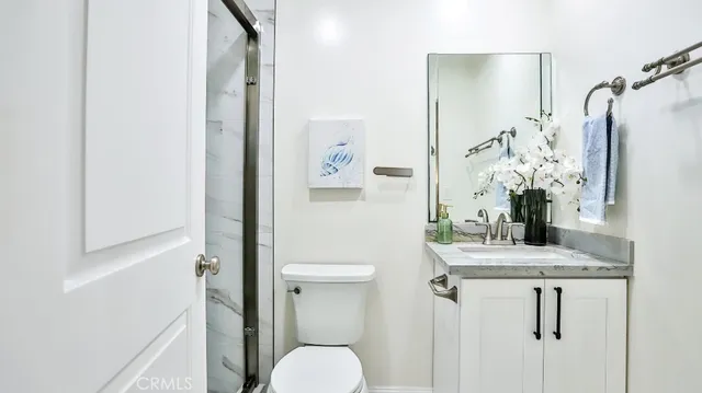 a bathroom with a granite countertop sink toilet and shower
