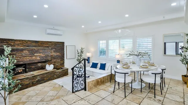 a living room with furniture a dining table and a fireplace
