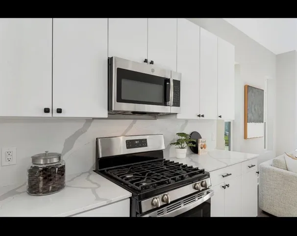 a kitchen with stainless steel appliances a stove a microwave and cabinets