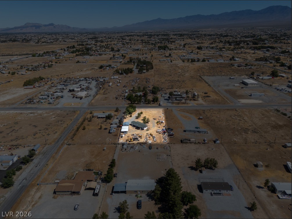 1301 East Manse Road Pahrump, NV 89048 - Photo 5 of 14 An aerial perspective reveals a vast, open landscape with a distant mountain range.