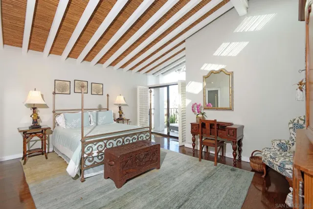 a large bedroom with a bed and wooden floor