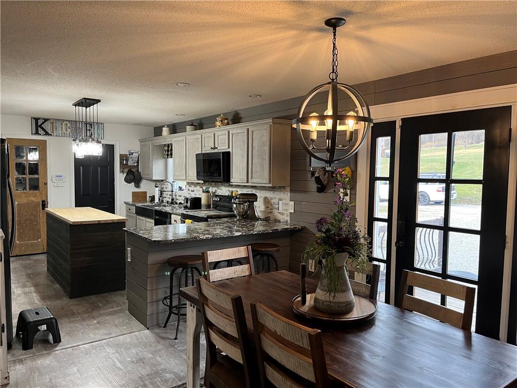129 Maple Street Rices Landing, PA 15357 - Photo 3 of 18 a kitchen with sink a refrigerator and chairs