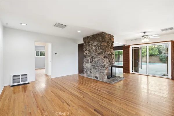 a view of empty room with wooden floor