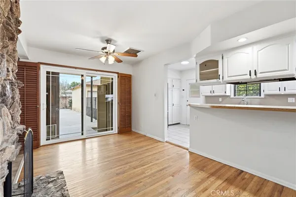 a view of a kitchen with wooden floor and a ceiling fan
