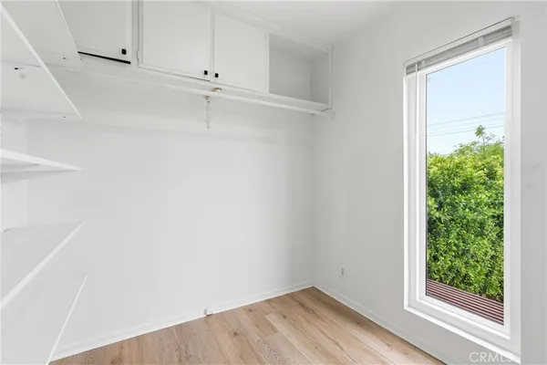 a view of a small space with wooden floor and a window
