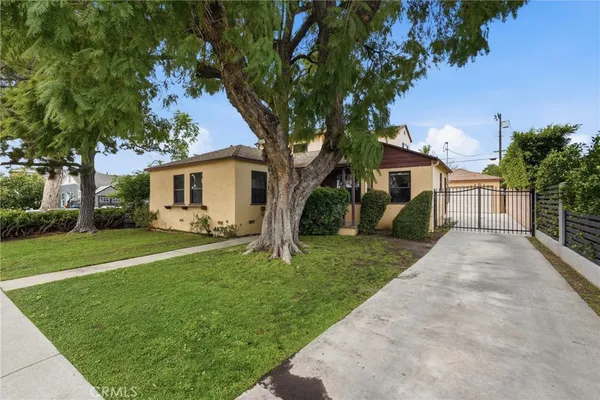 a white house that has a tree in front of it