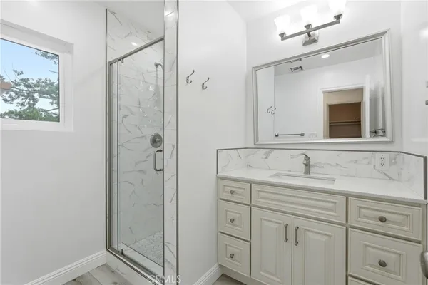 a bathroom with a shower sink and mirror
