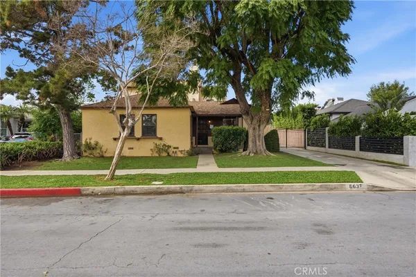 a view of a house with a big yard and large trees