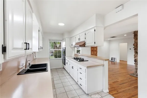 a large white kitchen with a stove top oven