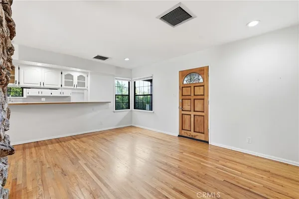 a view of empty room with wooden floor and window
