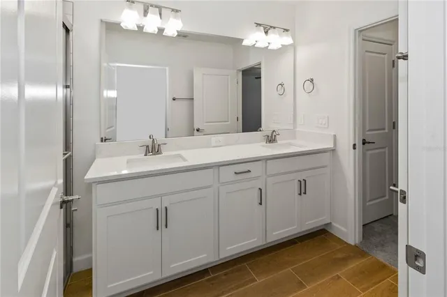 a bathroom with a double vanity sink mirror and