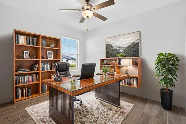 a view of a workspace with furniture and a bookshelf