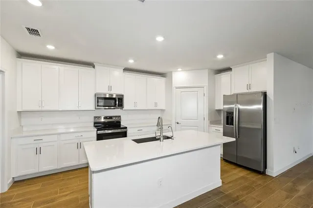 a kitchen with stainless steel appliances a refrigerator sink and microwave