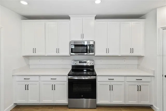 a kitchen with white cabinets and stainless steel appliances