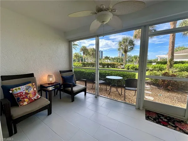 a living room with furniture a floor to ceiling window and a flat screen tv
