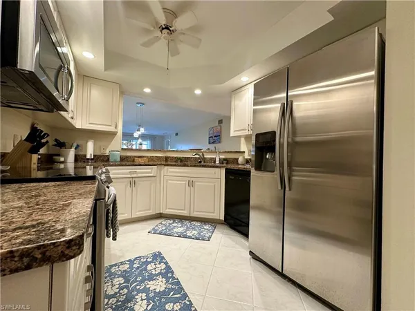 a kitchen with a refrigerator a sink and cabinets