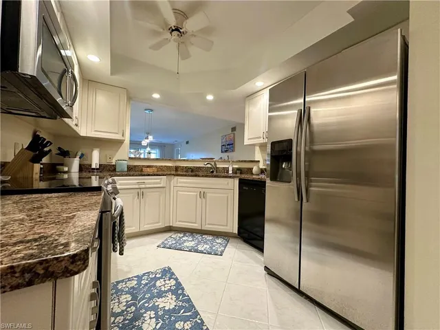 a kitchen with a refrigerator a sink and cabinets