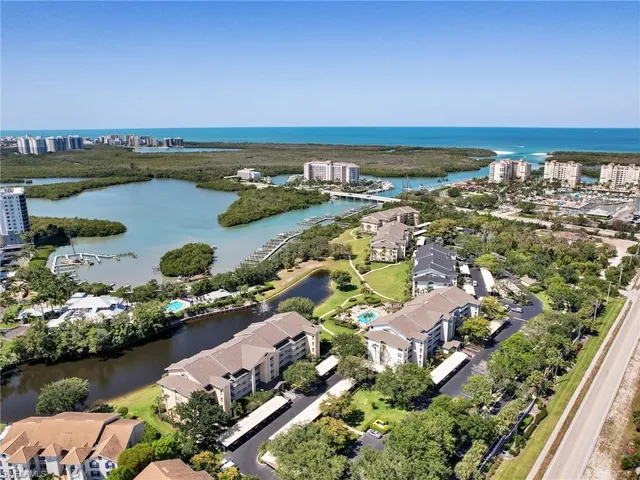 an aerial view of ocean and residential houses with outdoor space