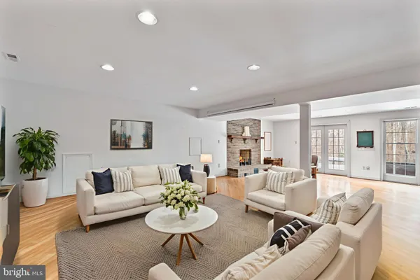 a living room with furniture potted plant and kitchen view