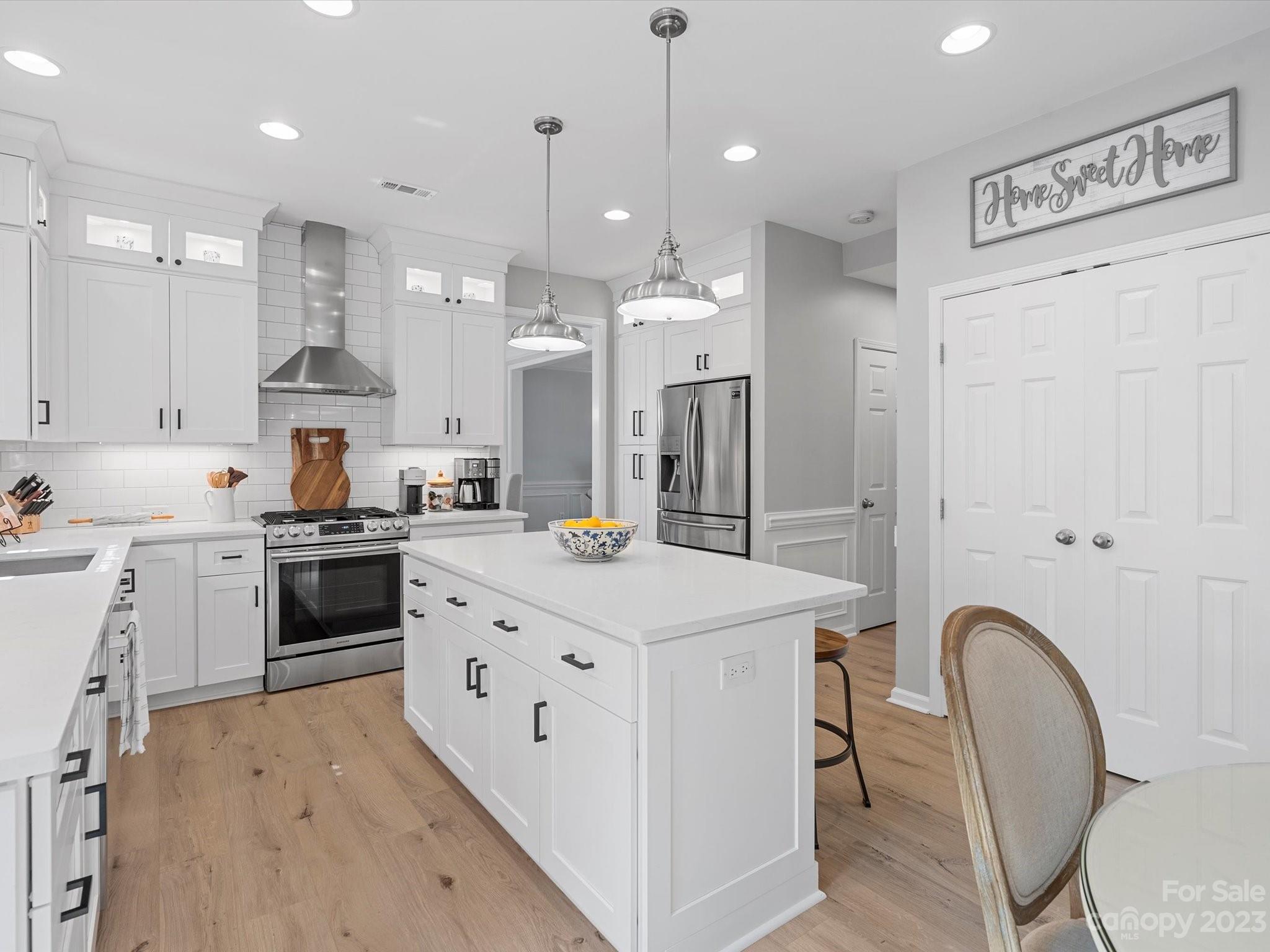 815 Circle Trace Road Monroe, NC 28110 - Photo 12 of 48 a kitchen with stainless steel appliances kitchen island granite countertop a stove a sink a refrigerator and white cabinets with wooden floor