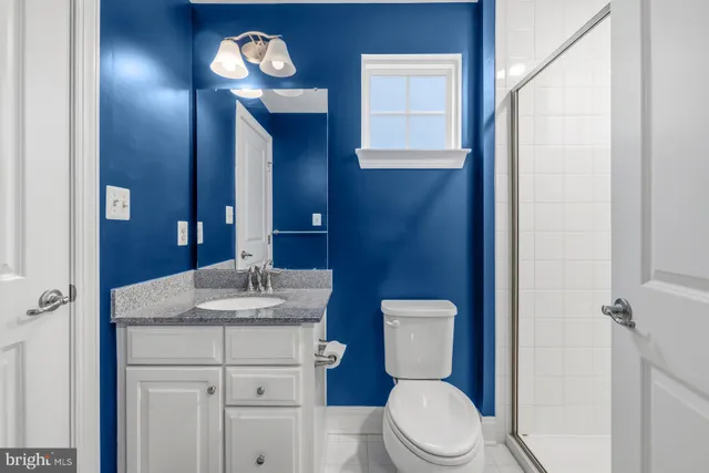 a bathroom with a granite countertop sink mirror and shower