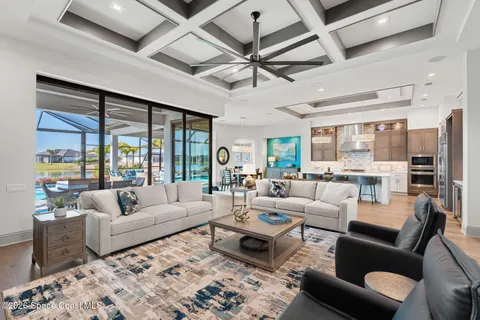 a living room with furniture a chandelier and a large window