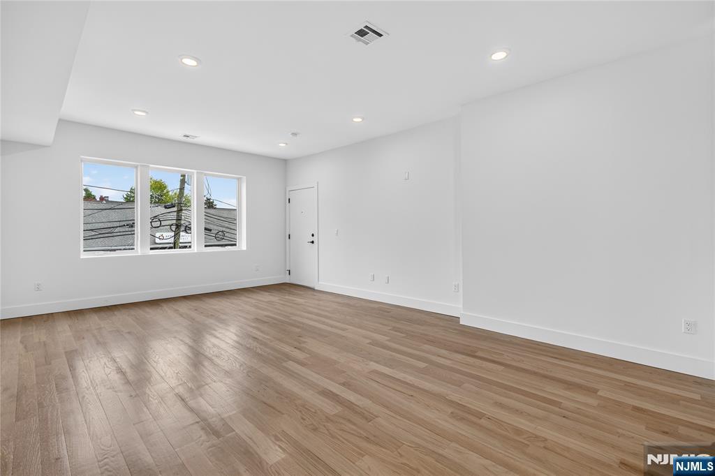 46 Hudson Avenue, Unit B Edgewater, NJ 07020 - Photo 7 of 30 a view of an empty room with wooden floor and a window