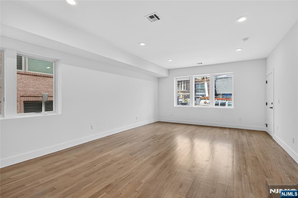 46 Hudson Avenue, Unit B Edgewater, NJ 07020 - Photo 8 of 30 a view of an empty room with wooden floor and a window