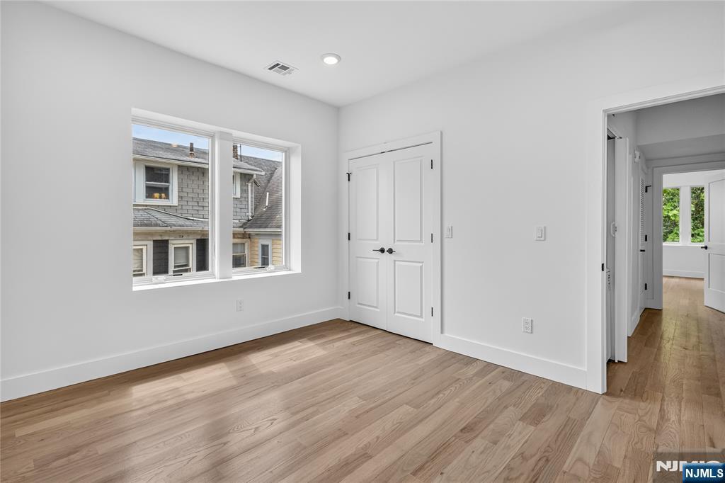 46 Hudson Avenue, Unit B Edgewater, NJ 07020 - Photo 9 of 30 a view of an empty room with wooden floor and a window