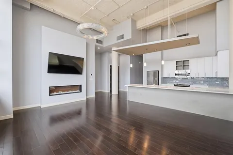 a view of a kitchen with stainless steel appliances wooden floor and a window