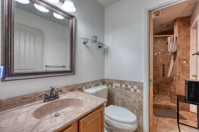 a bathroom with a sink a toilet and shower