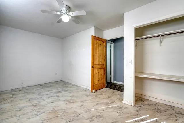 a view of an empty room with a ceiling fan
