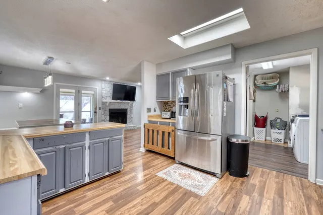 a kitchen with kitchen island wooden floors appliances and cabinets